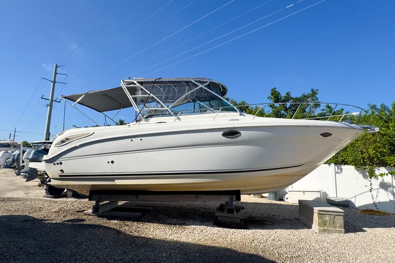 Slide: The Image of 2006 Sea Ray 290 Amberjack boat on display, side view under clear blue sky. - 34
