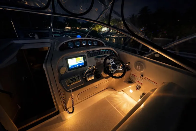 Slide: The Image of 2006 Sea Ray 290 Amberjack cockpit at night, featuring illuminated controls and navigation equipment. - 39