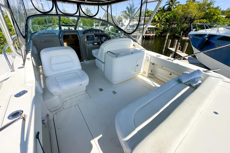 Slide: The Image of 2006 Sea Ray 290 Amberjack boat interior with white seating and helm, docked by water. - 4