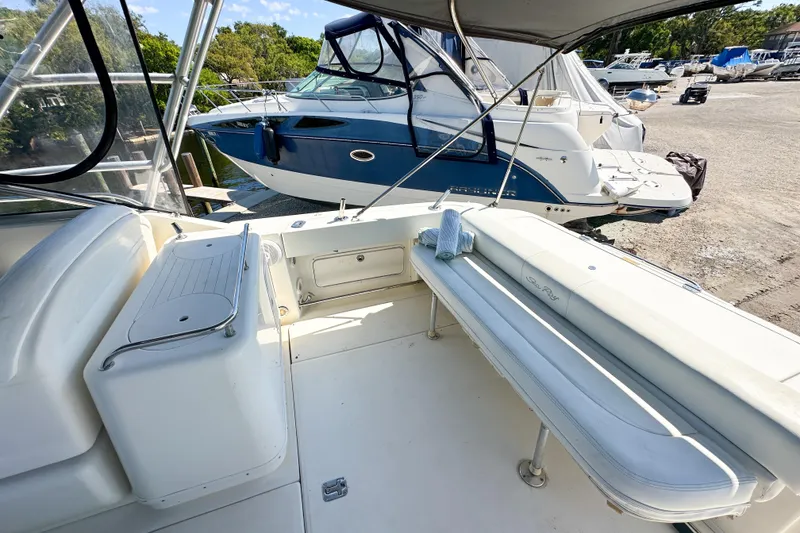 Slide: The Image of 2006 Sea Ray 290 Amberjack boat interior with seating and docked boats in background. - 5