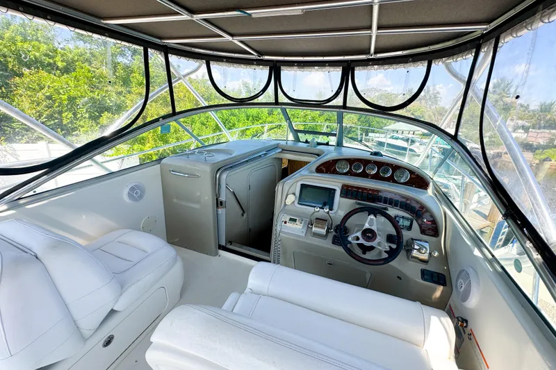 Slide: The Image of 2006 Sea Ray 290 Amberjack cockpit with steering wheel, gauges, and white seating. - 7