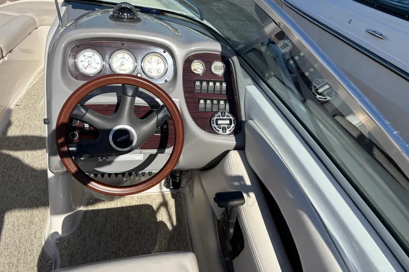 Slide: The Image of 2004 Chaparral 256 SSi boat dashboard with wood-trimmed steering wheel and instrument panel. - 6