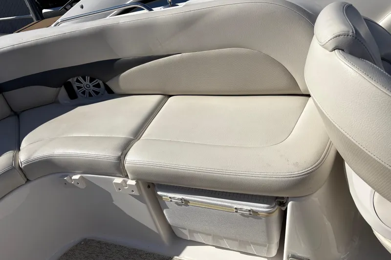 Slide: The Image of 2004 Chaparral 256 SSi boat interior with beige seating and built-in cooler. - 7
