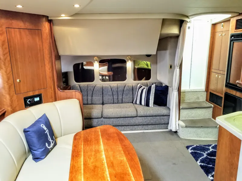 Slide: The Image of Interior of a 2000 Cruisers Yachts 3672 Express with sofa and wooden table. - 2