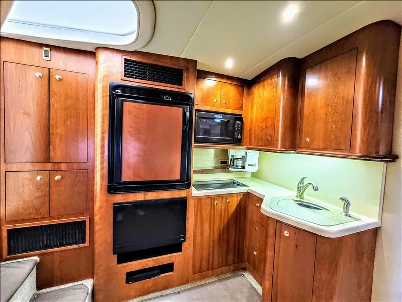 Slide: The Image of Interior of 2000 Cruisers Yachts 3672 Express with kitchen and wooden cabinets. - 30