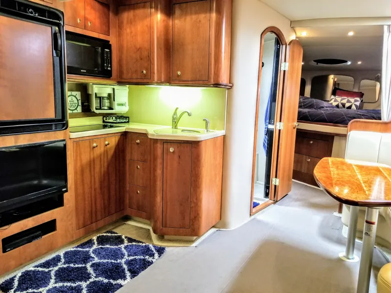 Slide: The Image of Interior of 2000 Cruisers Yachts 3672 Express with kitchen and dining area. - 9