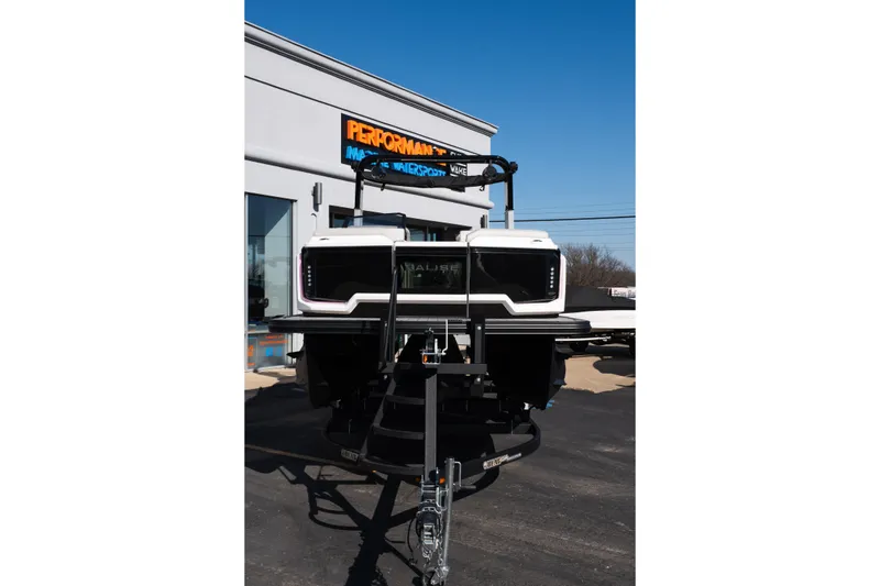 Slide: The Image of 2025 Balise Helix 24C boat displayed at dealership under clear blue sky. - 10