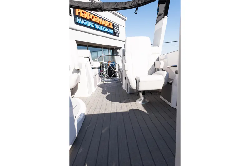 Slide: The Image of Interior view of 2025 Balise Helix 24C boat with white seating and marine dealership sign. - 29