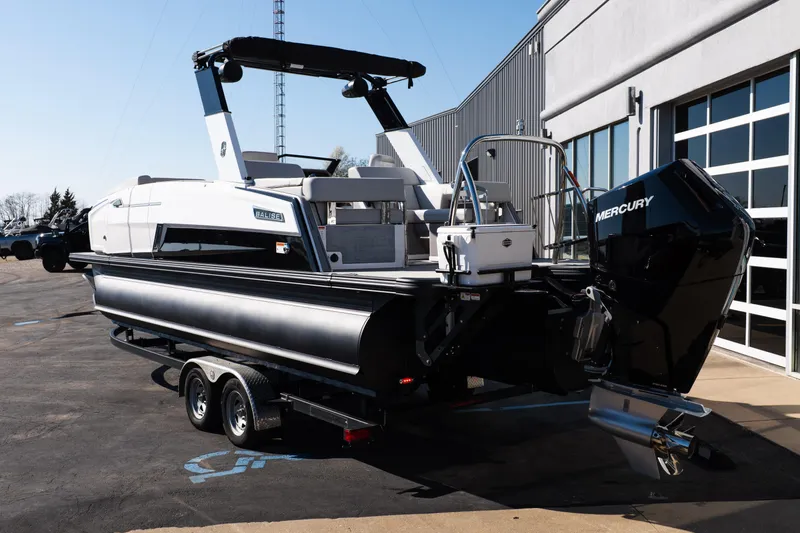 Slide: The Image of 2025 Balise Helix 24C boat with Mercury engine on trailer, parked outside a building. - 4