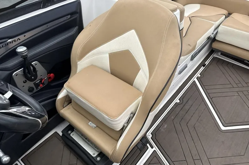 Slide: The Image of 2018 Supra SA 550 boat interior with beige and white seating, steering wheel, and controls. - 13