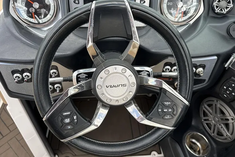 Slide: The Image of Steering wheel of 2018 Supra SA 550 boat with control buttons and gauges. - 14