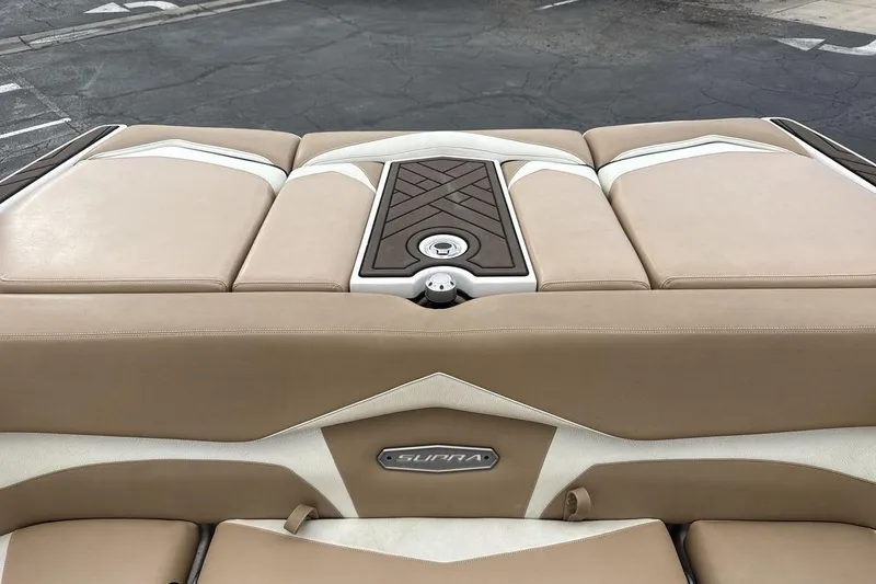 Slide: The Image of 2018 Supra SA 550 boat interior with beige and white upholstery, featuring a central panel. - 19