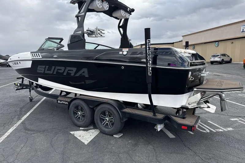 Slide: The Image of 2018 Supra SA 550 boat on trailer in parking lot, black and white design. - 3