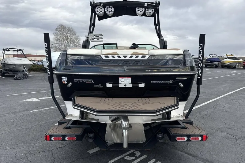 Slide: The Image of 2018 Supra SA 550 boat rear view in parking lot, showcasing sleek design and features. - 4
