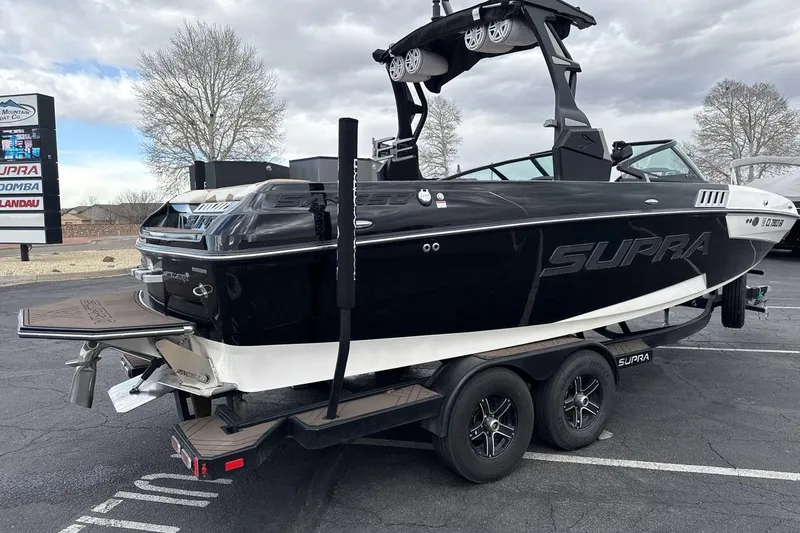 Slide: The Image of 2018 Supra SA 550 boat on trailer, black and white design, parked outdoors. - 5