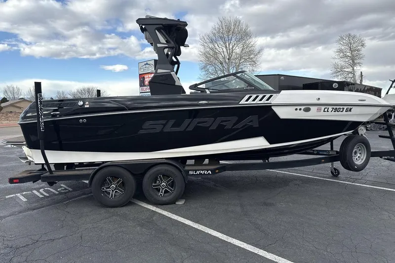 Slide: The Image of 2018 Supra SA 550 boat on trailer in parking lot under cloudy sky. - 6