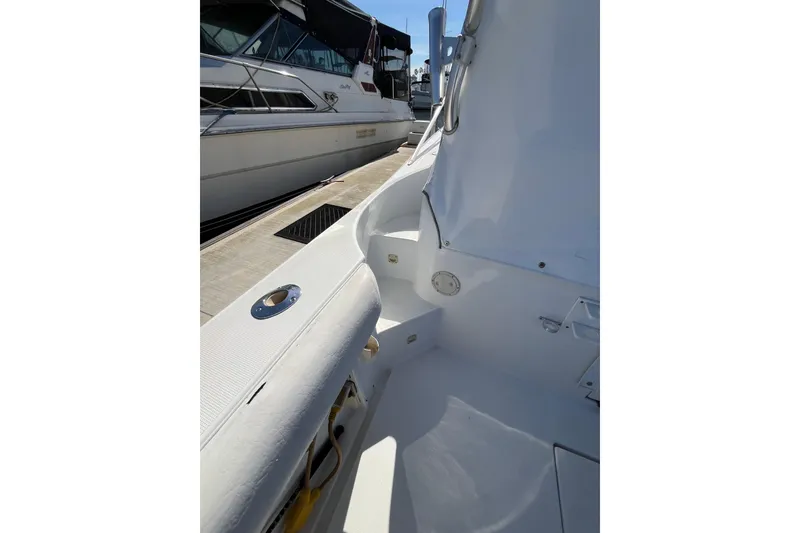 Slide: The Image of 1998 Phoenix 32 Tournament boat interior, docked beside another vessel. - 12