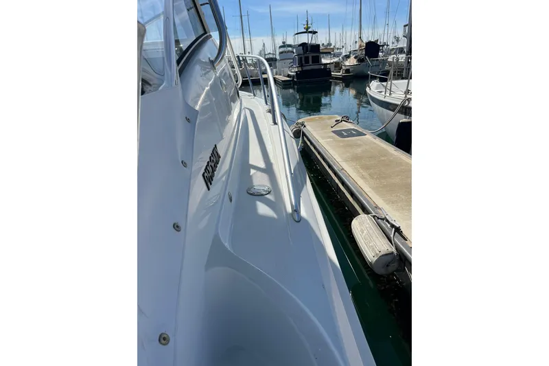 Slide: The Image of 1998 Phoenix 32 Tournament boat docked in a marina, surrounded by other vessels. - 13