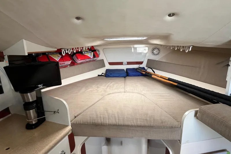 Slide: The Image of Interior cabin of 1998 Phoenix 32 Tournament boat with cozy bedding and fishing rods. - 16
