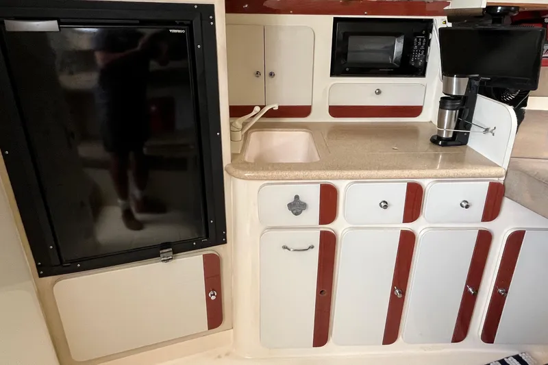 Slide: The Image of 1998 Phoenix 32 Tournament boat kitchen with sink, fridge, microwave, and coffee maker. - 17
