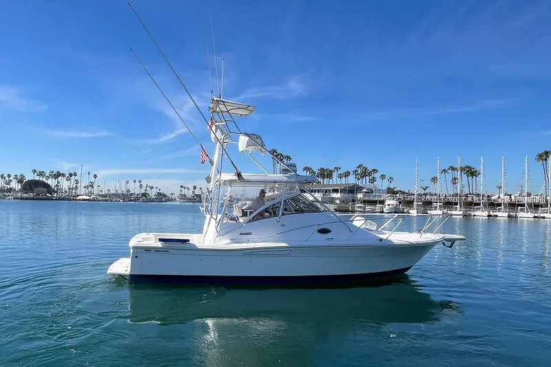 Slide: The Image of 1998 Phoenix 32 Tournament boat on calm water, clear sky, marina background. - 2