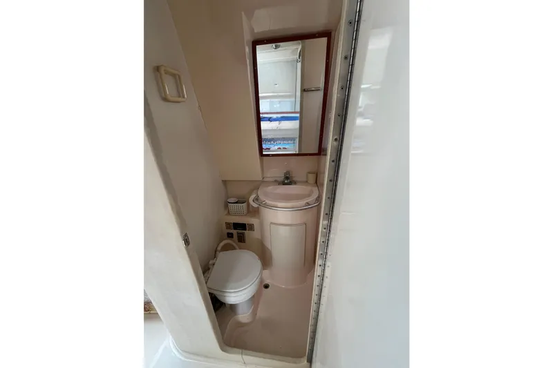 Slide: The Image of Compact bathroom in 1998 Phoenix 32 Tournament boat with sink, toilet, and mirror. - 21