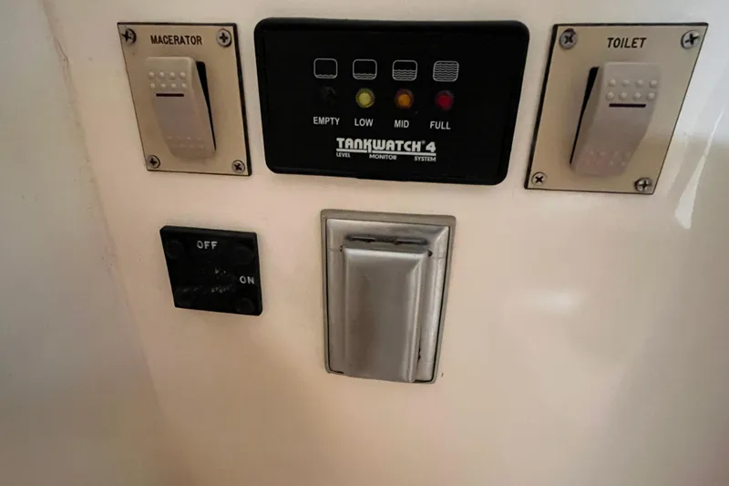 Slide: The Image of Control panel of a 1998 Phoenix 32 Tournament boat with macerator and toilet switches. - 23