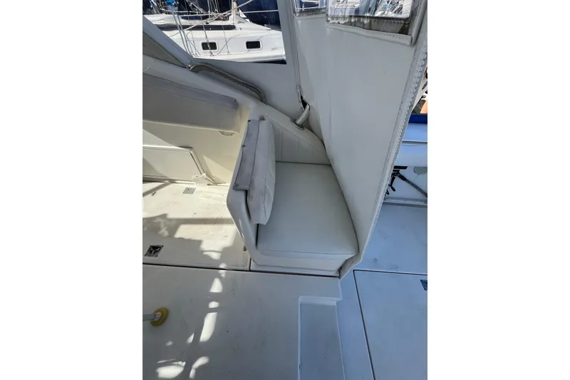 Slide: The Image of Interior seating of 1998 Phoenix 32 Tournament boat, featuring white upholstery and compact design. - 8