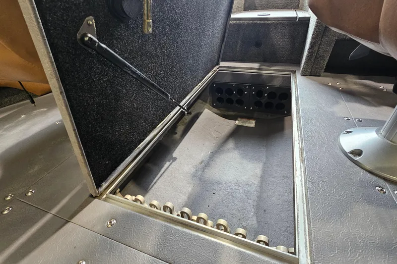 Slide: The Image of 2019 Princecraft Platinum SE 227 boat storage compartment with open hatch and rod holders. - 19