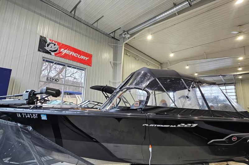 Slide: The Image of 2019 Princecraft Platinum SE 227 boat in a showroom with Mercury banner. - 3