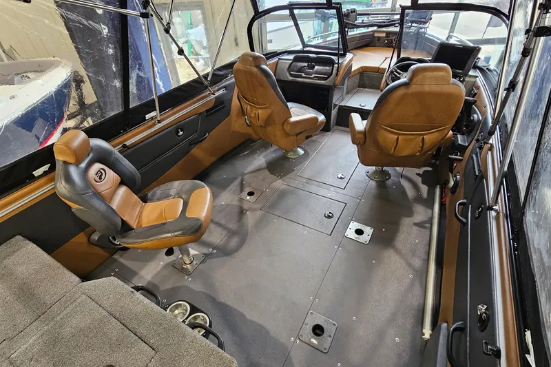 Slide: The Image of 2019 Princecraft Platinum SE 227 boat interior with brown seating and modern dashboard. - 9