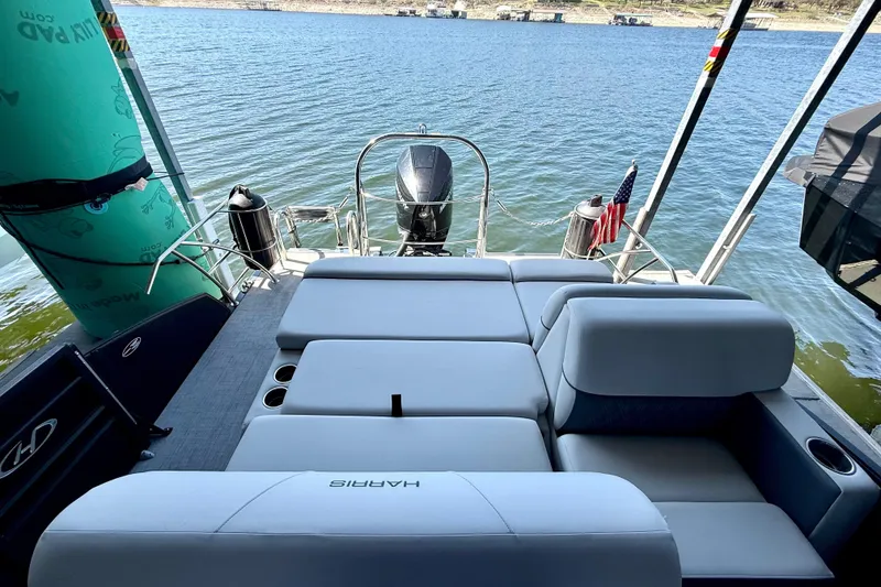 Slide: The Image of 2022 Harris Sunliner 250 pontoon boat with spacious seating on a serene lake. - 15