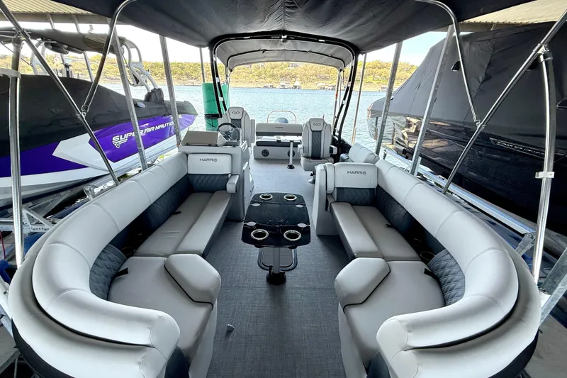 Slide: The Image of 2022 Harris Sunliner 250 pontoon boat with spacious seating and modern interior design. - 16