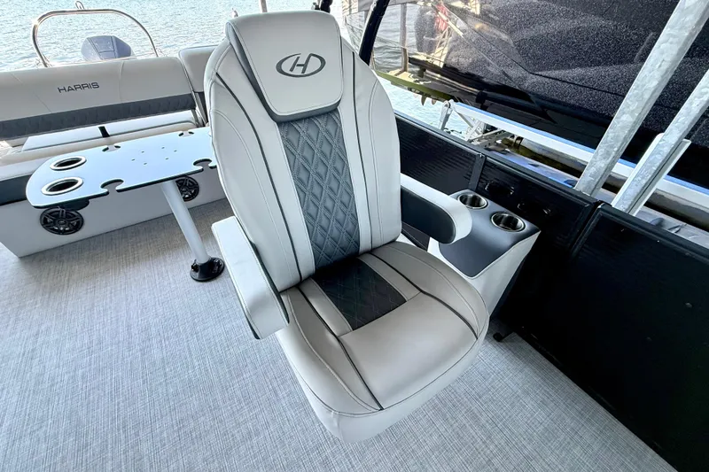 Slide: The Image of 2022 Harris Sunliner 250 boat interior with luxury captain's chair and cup holders. - 22