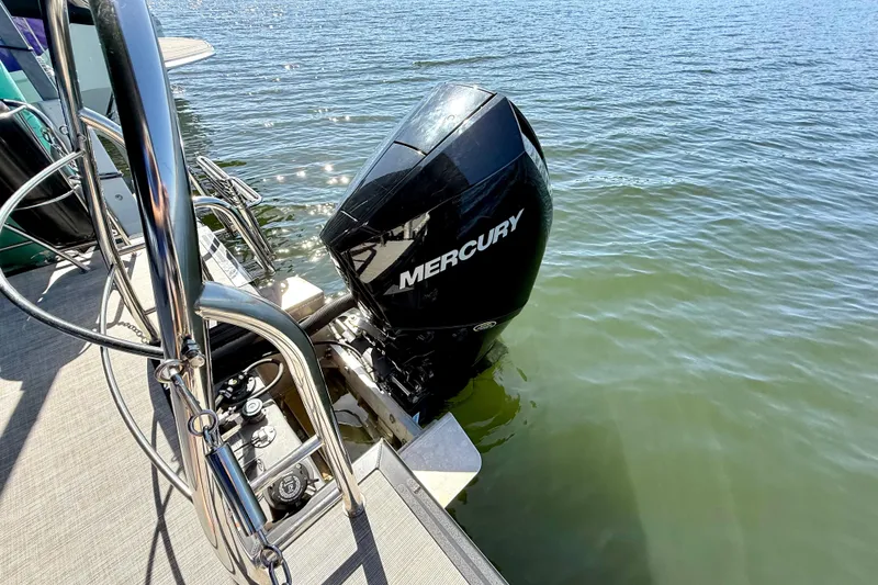 Slide: The Image of 2022 Harris Sunliner 250 with Mercury outboard motor on calm water. - 24