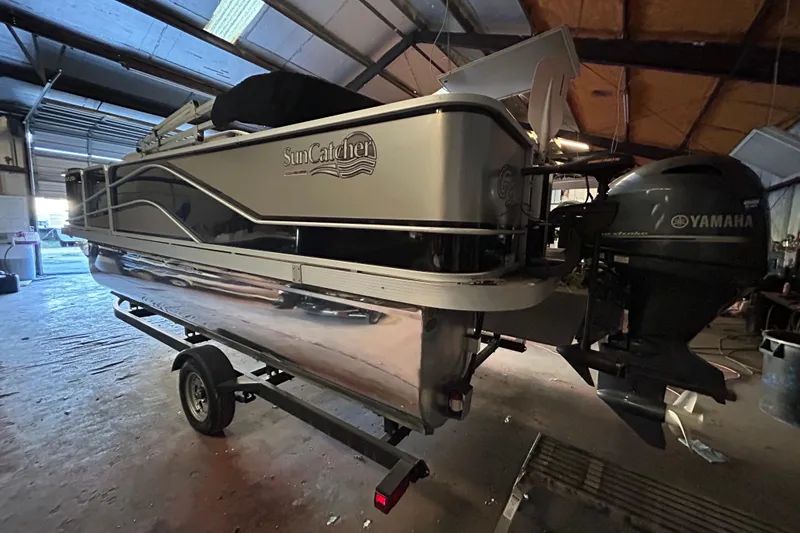 Slide: The Image of 2018 SunCatcher V20 Fish pontoon boat with Yamaha motor in a garage setting. - 10