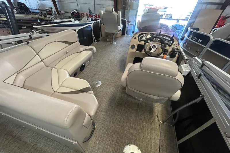Slide: The Image of 2018 SunCatcher V20 Fish boat interior with beige seating and steering console. - 19
