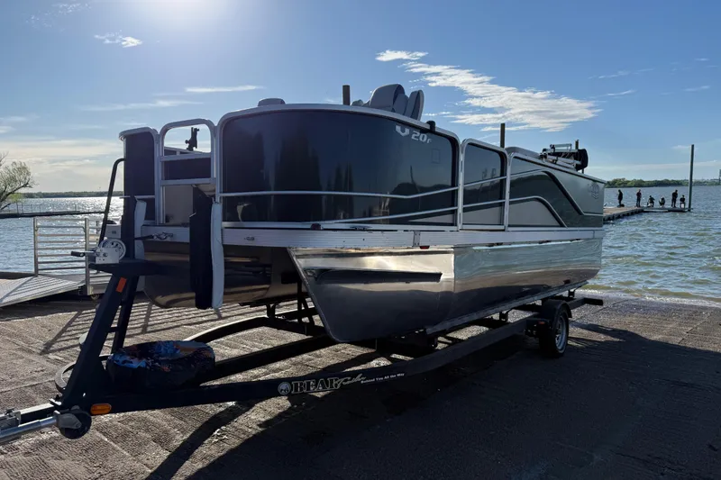Slide: The Image of 2018 SunCatcher V20 Fish pontoon boat on trailer by a lake. - 26