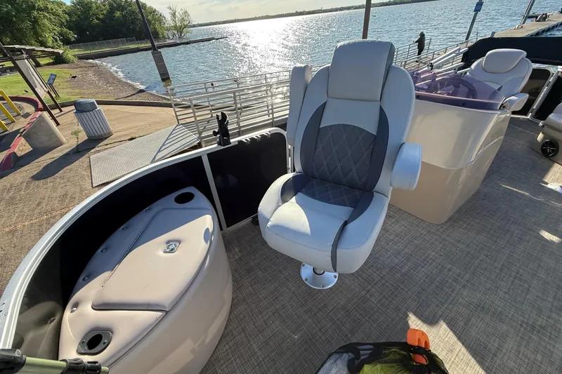 Slide: The Image of 2018 SunCatcher V20 Fish boat interior with seating, docked by a scenic lake. - 30