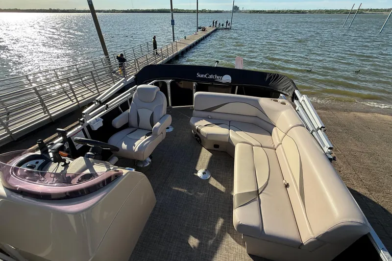 Slide: The Image of 2018 SunCatcher V20 Fish pontoon boat with beige seating, docked by a sunny lake. - 33