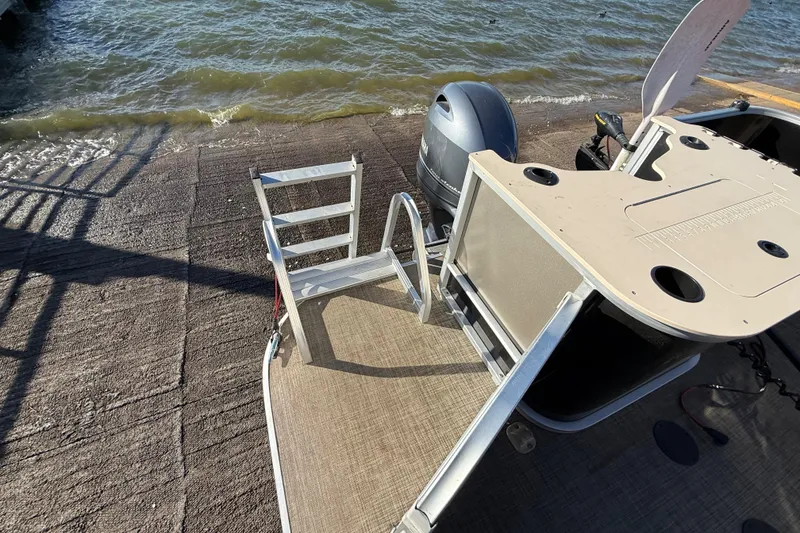 Slide: The Image of 2018 SunCatcher V20 Fish boat at lakeside with motor and fishing setup. - 38