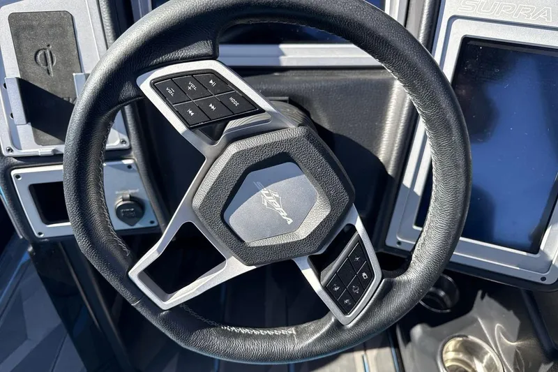 Slide: The Image of Steering wheel of a 2021 Supra SA 450 boat with control buttons. - 14