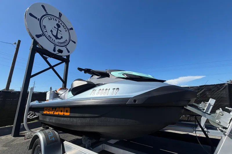 The Image of 2023 Sea-Doo GTI 130 jet ski on trailer under clear blue sky. - 0