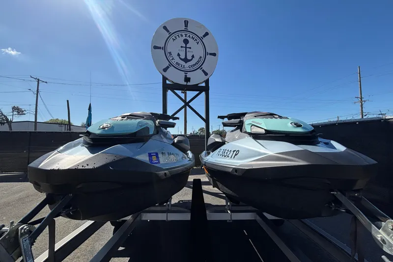 Slide: The Image of Two 2023 Sea-Doo GTI 130 jet skis on a trailer under a clear blue sky. - 12