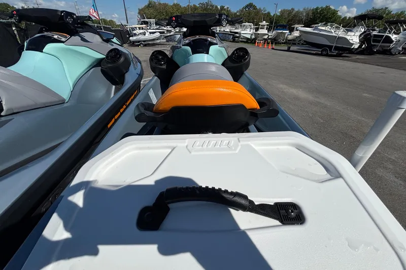 Slide: The Image of 2023 Sea-Doo GTI 130 jet ski with orange seat, parked among boats. - 19