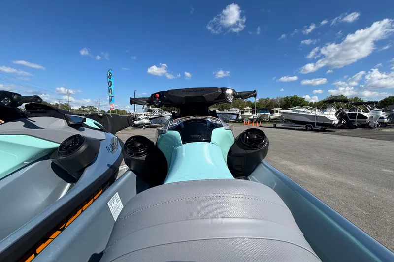 Slide: The Image of 2023 Sea-Doo GTI 130 jet ski displayed at a boat dealership under a clear blue sky. - 23