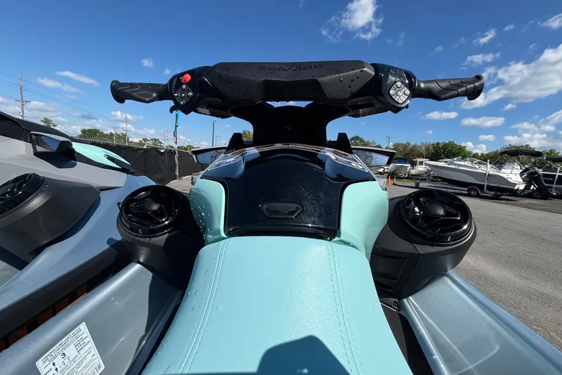 Slide: The Image of 2023 Sea-Doo GTI 130 jet ski dashboard with handlebars, outdoors under blue sky. - 24
