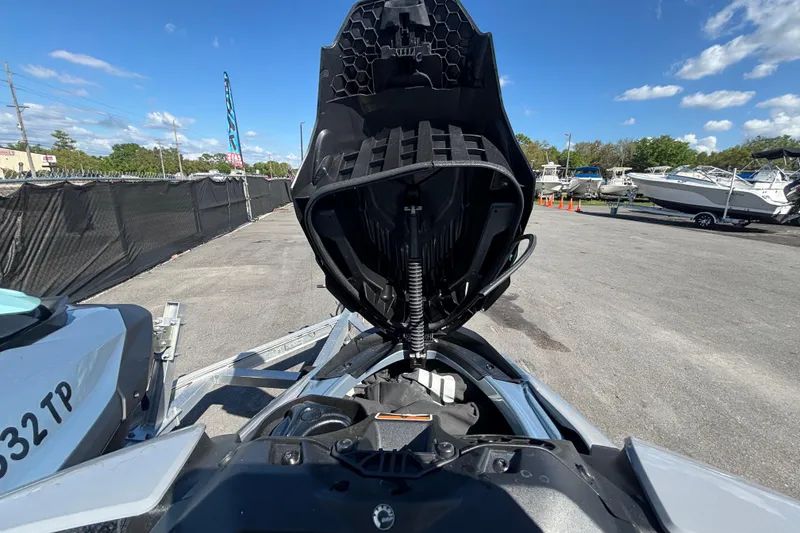 Slide: The Image of 2023 Sea-Doo GTI 130 with open storage compartment, parked outdoors under blue sky. - 27
