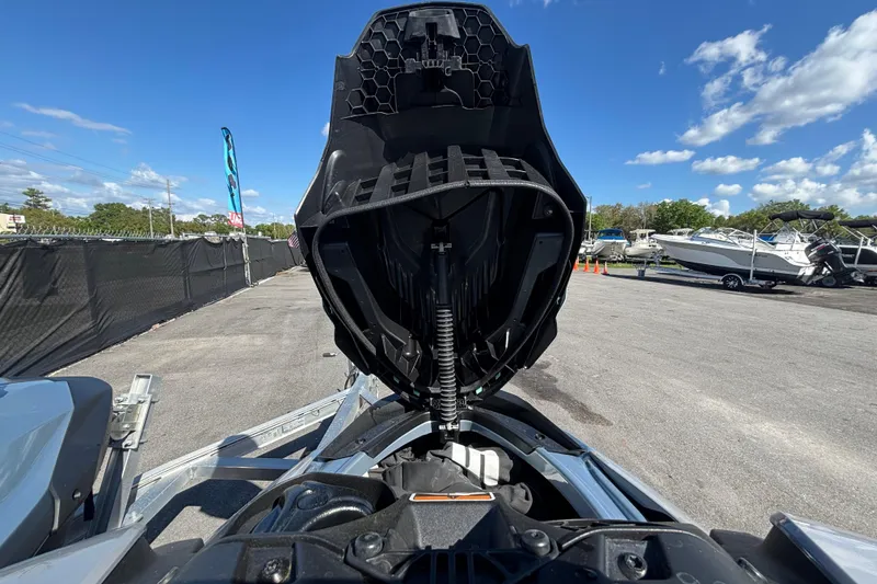 Slide: The Image of 2023 Sea-Doo GTI 130 with open storage compartment, parked outdoors under a clear blue sky. - 28
