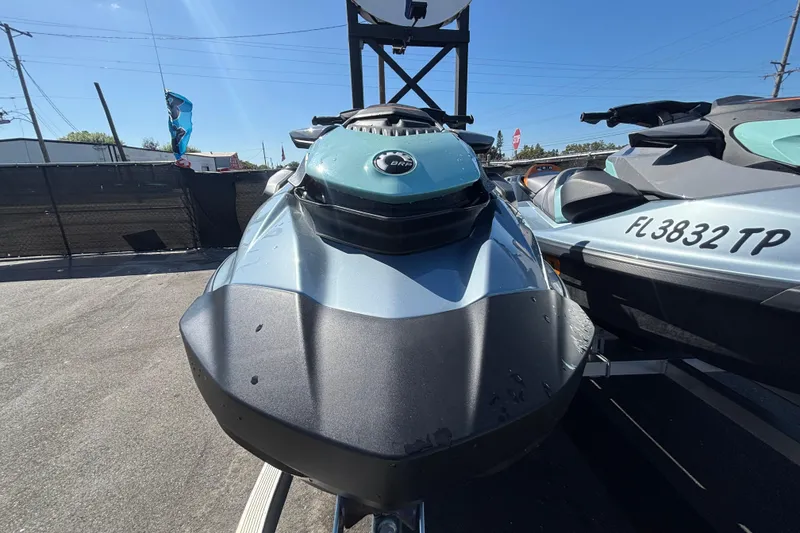 Slide: The Image of 2023 Sea-Doo GTI 130 jet ski in a parking lot under clear blue sky. - 30